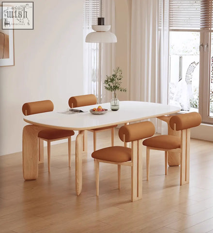 Modern minimalist domingo dining table with sleek white sintered stone top and light wood legs with tan leather chairs