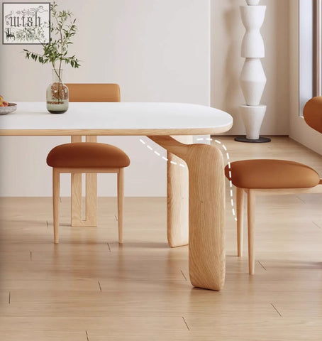 Modern minimalist domingo dining table with white sintered stone top and light wood legs with sleek curves