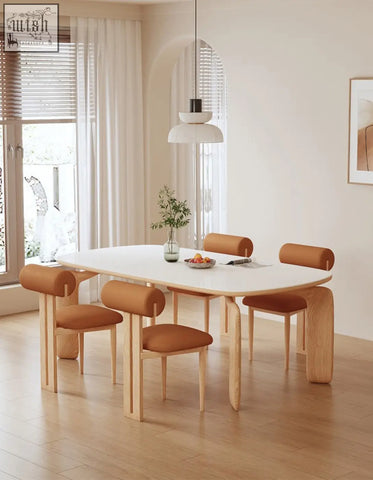 Modern oval domingo dining table with smooth white sintered stone surface and light wood legs with brown chairs