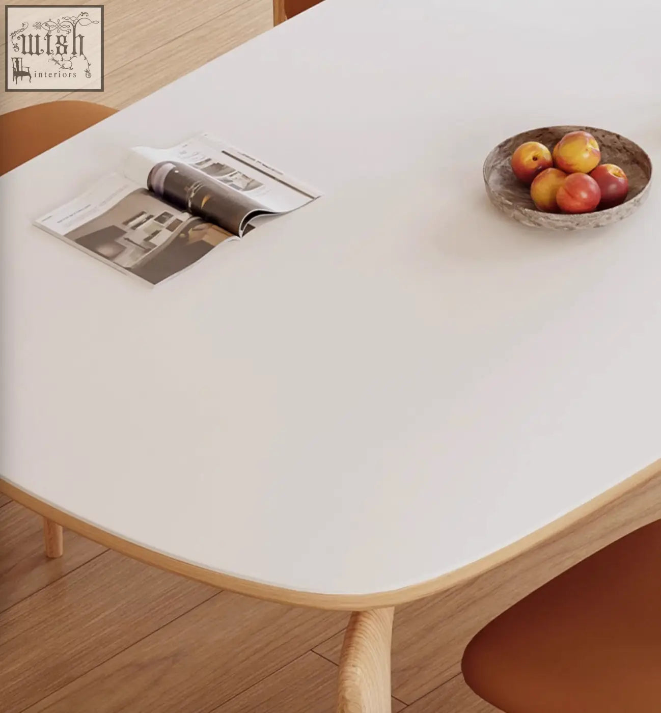 A rustic speckled ceramic bowl with red and yellow peaches on the domingo dining table with sintered stone top
