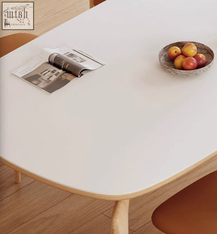 A rustic speckled ceramic bowl with red and yellow peaches on the domingo dining table with sintered stone top