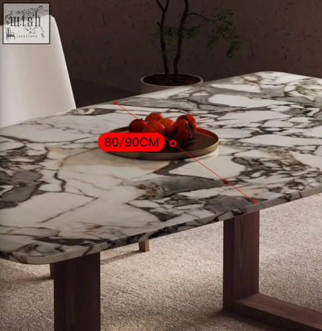 A sleek donovan dining table with white and gray marble top and dark wood legs perfect for modern dining spaces