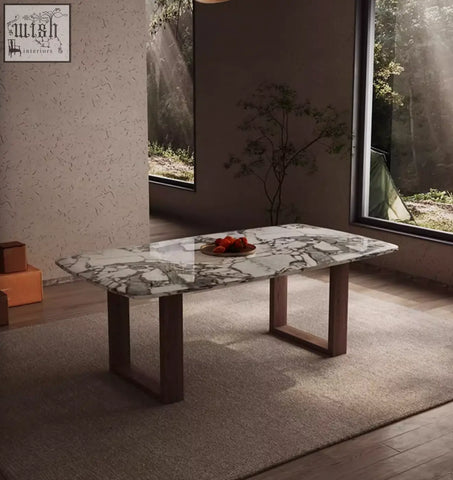 A sleek donovan dining table with a white and gray marble top and dark wood legs perfect for dining spaces