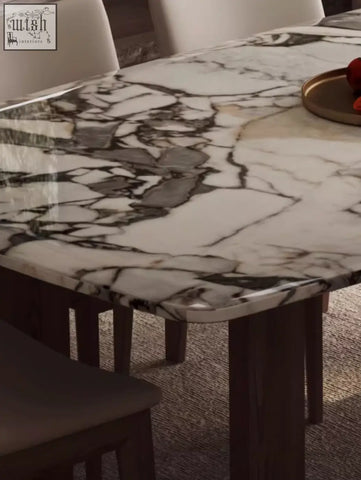 A sleek white marble donovan dining table with black and gray veining and dark wooden legs for stylish dining