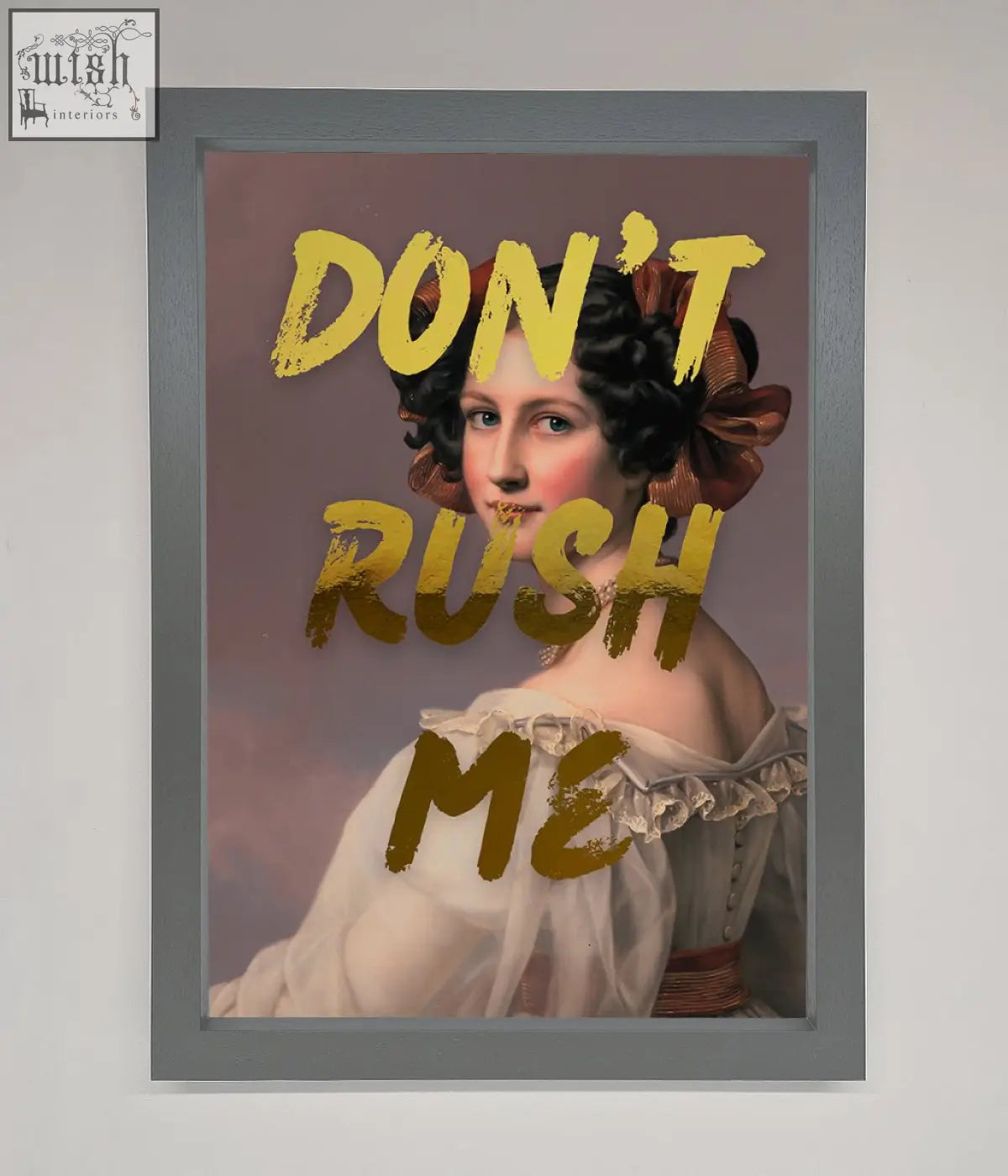 A framed dont rush me foil print featuring a woman in a white off the shoulder gown with a brown bow on her hair