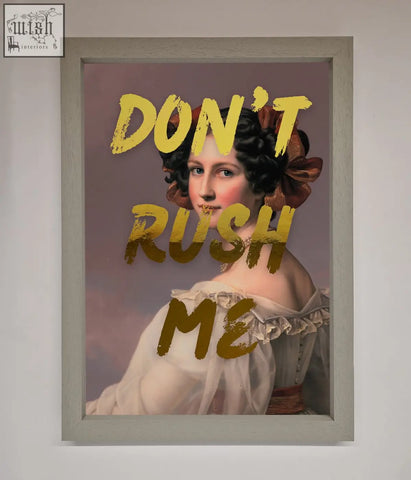 A framed dont rush foil print featuring a woman in a white gown with dark hair and bold yellow text about shipping time