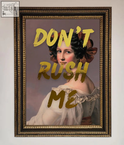 A framed dont rush foil print featuring a woman in a white gown with dark curls and a brown bow about shipping time