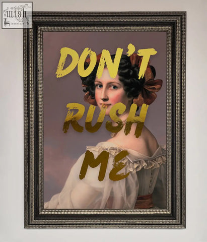 A framed dont rush me foil print featuring a woman in a white off-the-shoulder gown with a brown bow on her hair