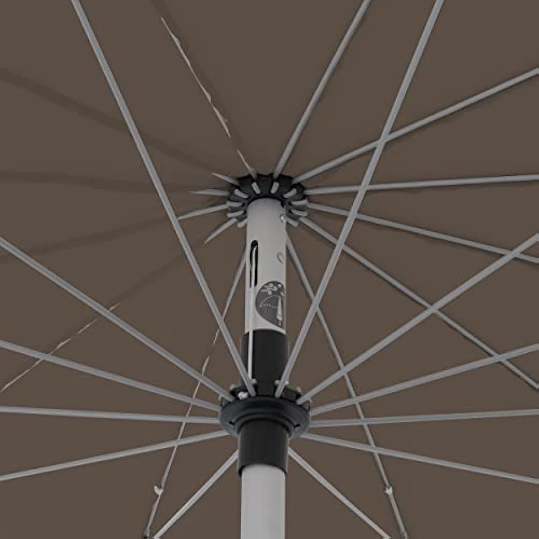Close-up of doppler greige taupe crank umbrella with white aluminum pole and black accents in outdoor garden use