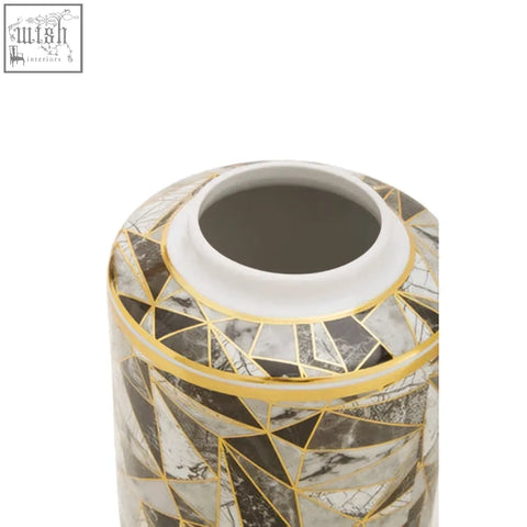 A cylindrical ceramic jar with a gray and white marble effect pattern and thin gold lines in a mosaic design