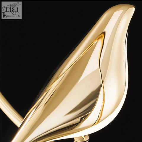 A sleek golden double chirpy led bird wall light with polished metallic finish and smooth flowing curves for nurseries