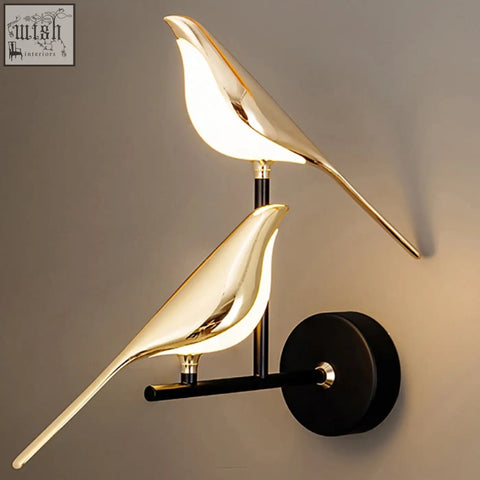 Gold-colored sleek double chirpy led bird wall light with polished metallic finish and black mounting base for nursery use
