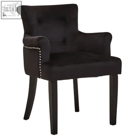 Black velvet dining chair with tufted back and silver nailhead trim perfect for elegant dining rooms
