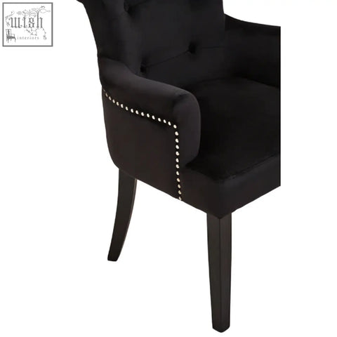 Black velvet dining chair with ring back and nailhead trim featuring a black tufted velvet armchair design
