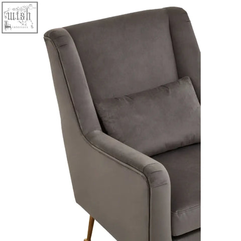A plush grey velvet doucet chair with matching cushion and elegant gold finish legs for stylish seating