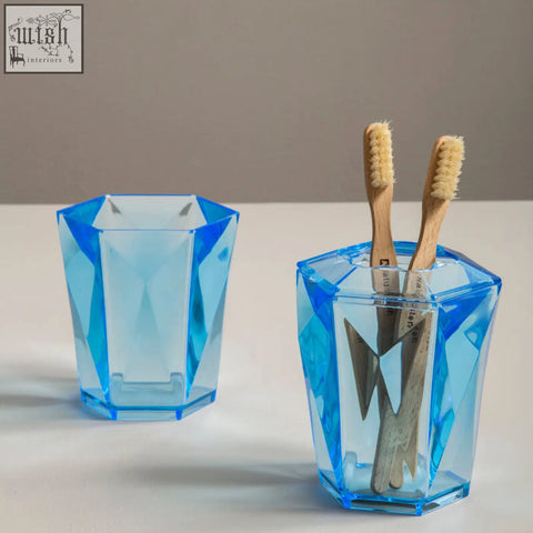Dow blue acrylic toothbrush holder with a blue acrylic geometric faceted translucent design for bathroom use