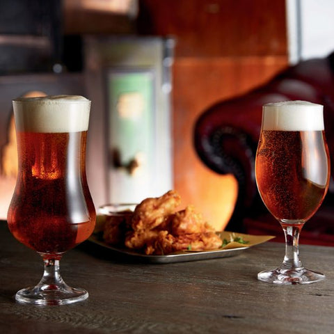 Two amber beers in 375ml stemmed beer glasses with creamy heads from a set of 6 draft stemmed beer glasses