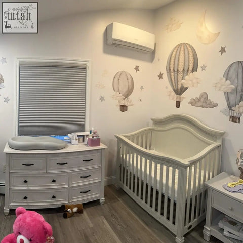White wooden crib with curved headboard and dreamy hot air balloons wall decals for nursery and kids room