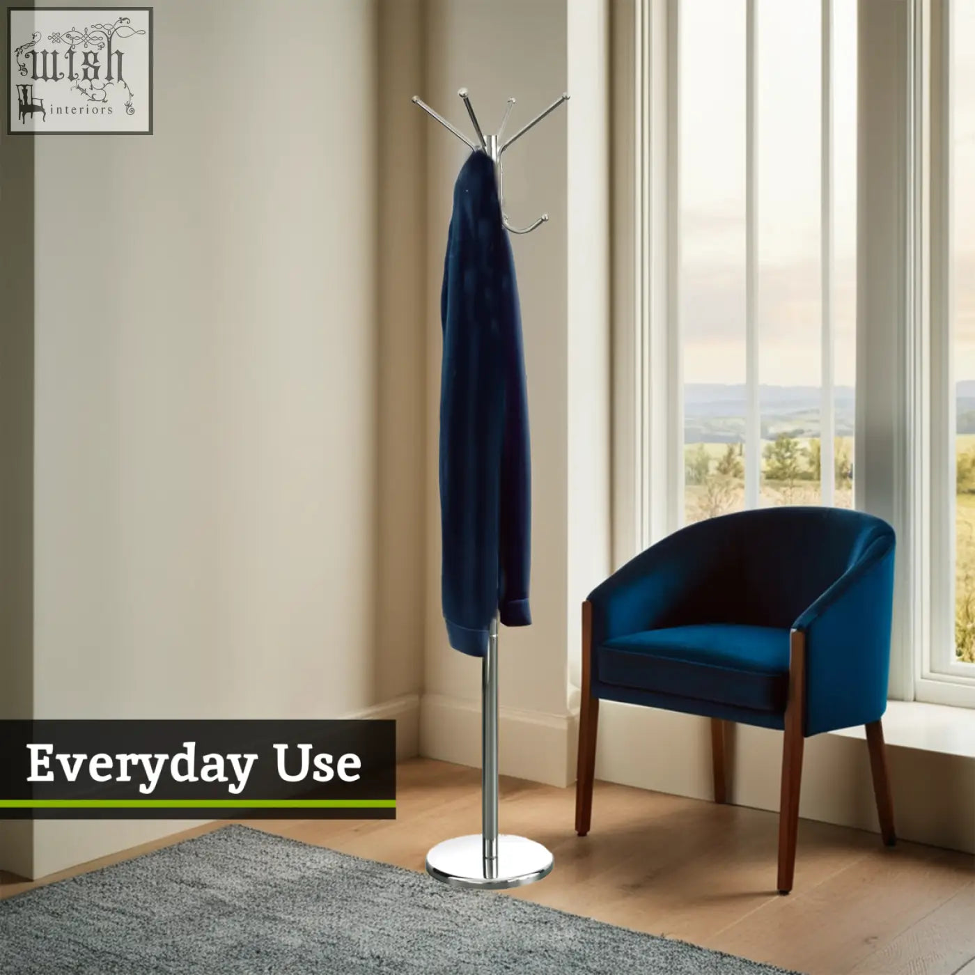 A sleek chrome finished floor standing coat stand holding a navy blue velvet jacket with multiple hooks