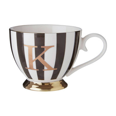 A duchess black and white monogram mug with bold black stripes gold-coated base and letter k on white ceramic teacup