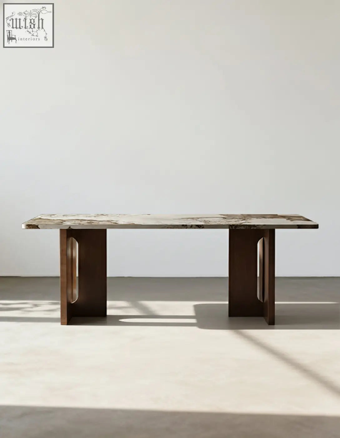 A sleek dudley dining table with a polished marble effect top and dark brown wooden legs with oval cutouts