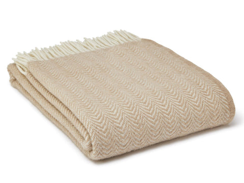 Beige dune pure new wool throw with herringbone pattern and cream-colored fringe perfect for cozying up