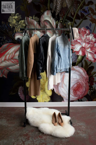 Black metal clothing rack with jackets and coats in living space showcasing peel and stick traditional paper mural by clickwalls