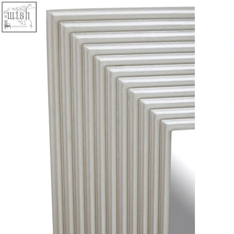 A sleek off-white framed silver wall mirror with a modern ribbed design perfect for stylish wall decor