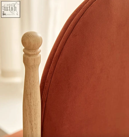 Back of a warm terracotta velvet ealing high-back dining chair with light wood spindle leg and rounded knob top