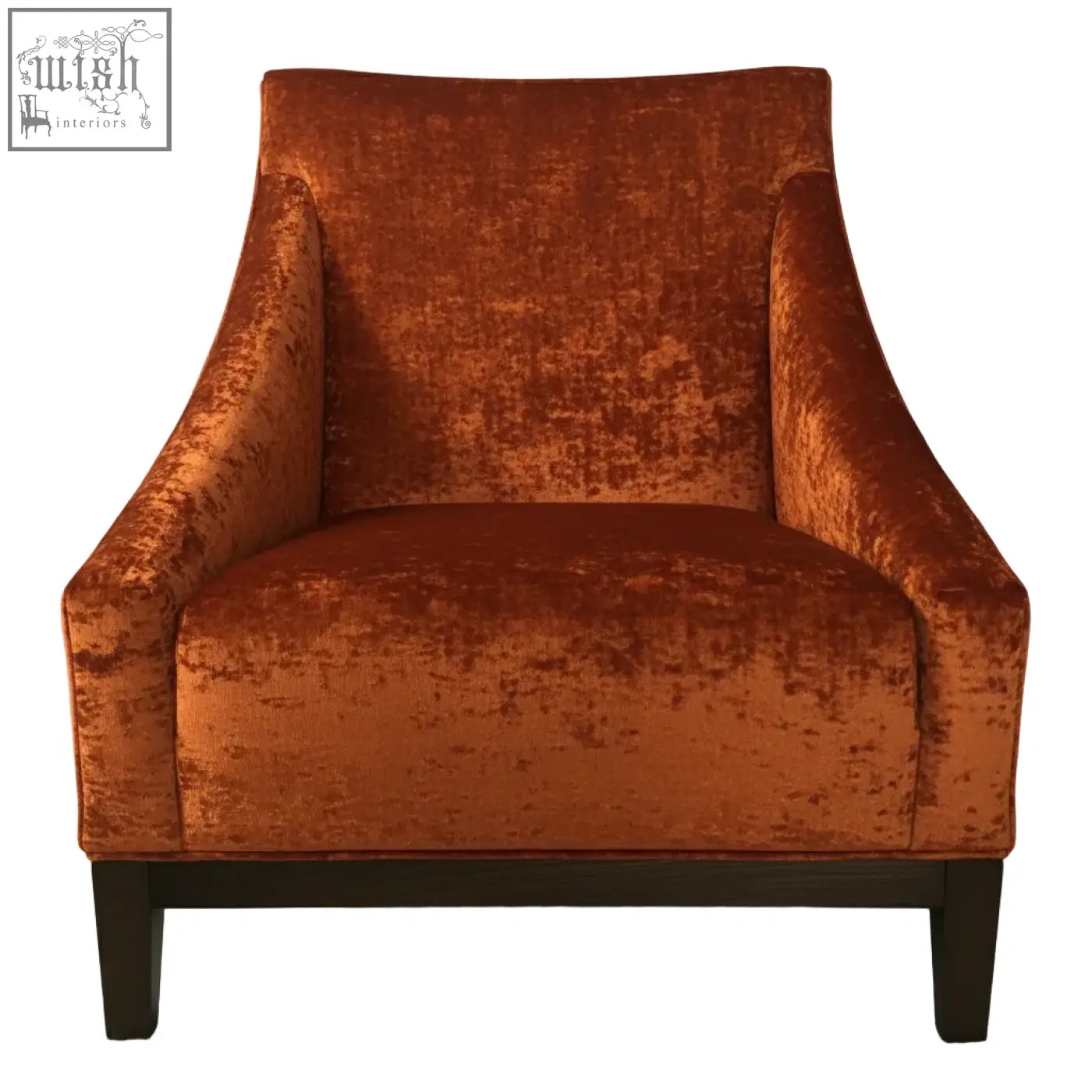 A plush burnt orange velvet ease arm chair with a high back and dark wooden legs for cozy seating