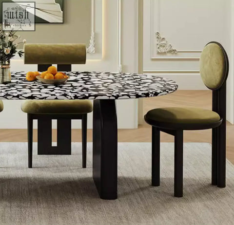 Modern eaton dining table with black and white terrazzo top and dark matte legs paired with olive green velvet chairs