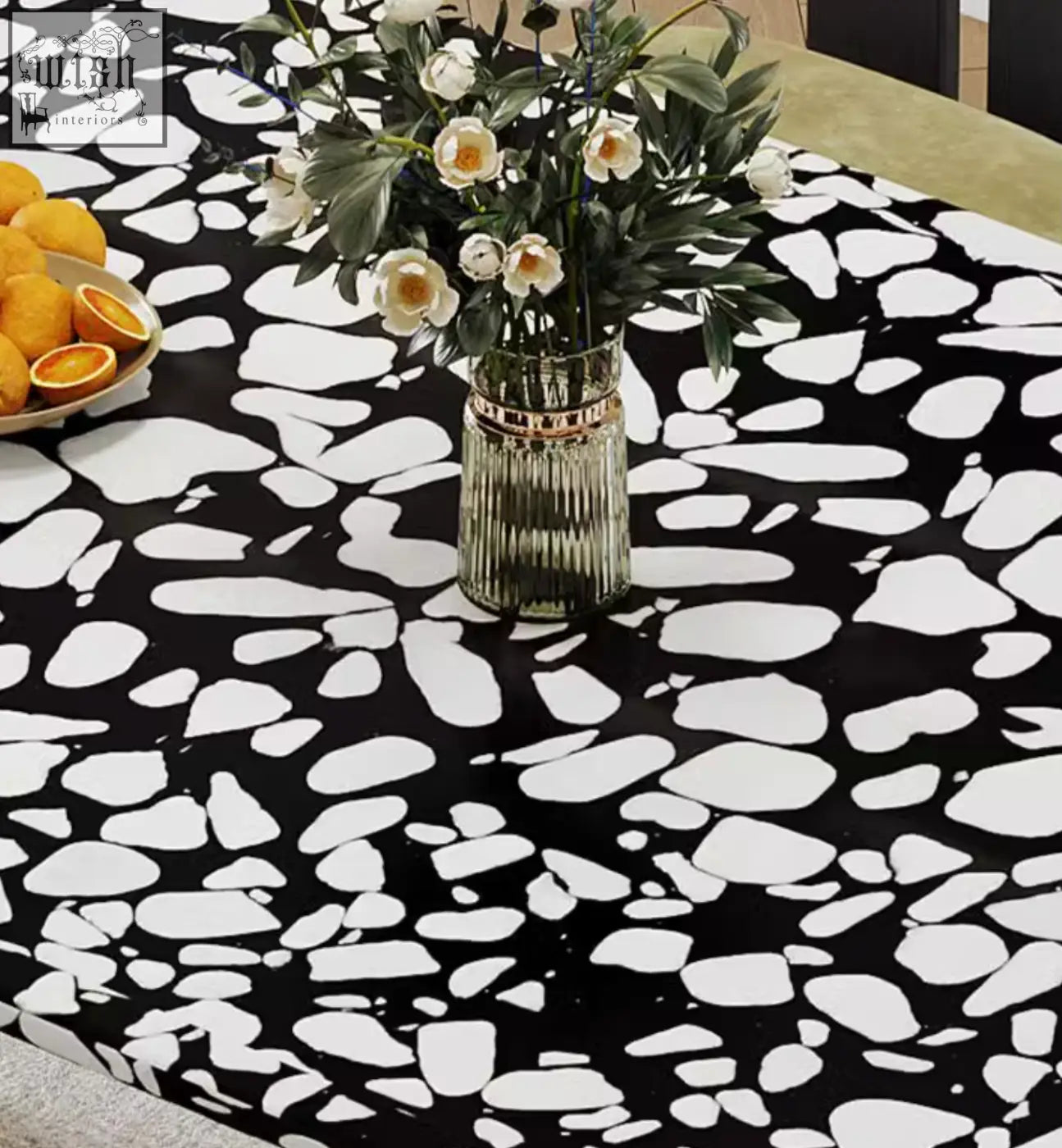 A ribbed glass vase with a gold metallic band on the black terrazzo eaton dining table centerpiece