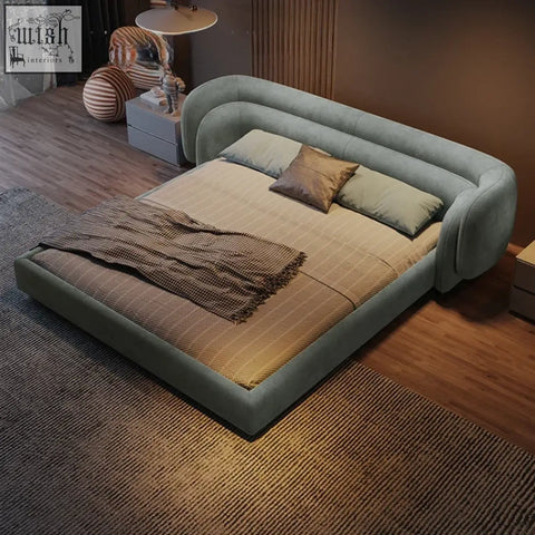 Modern sage green eclipse bed with rounded frame and plush upholstery featuring curved headboard and footboard