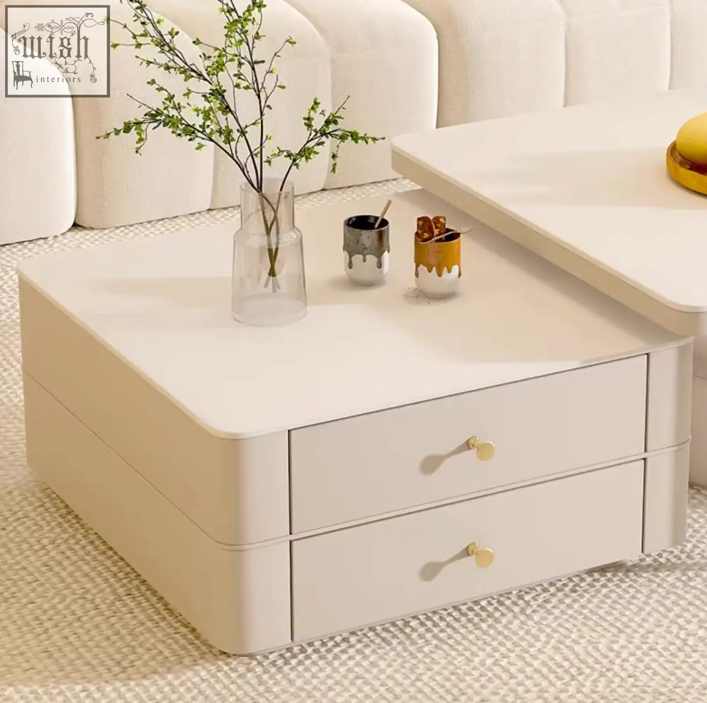 Cream-colored eclipse nesting coffee table with two drawers and gold-tone handles in a modern design