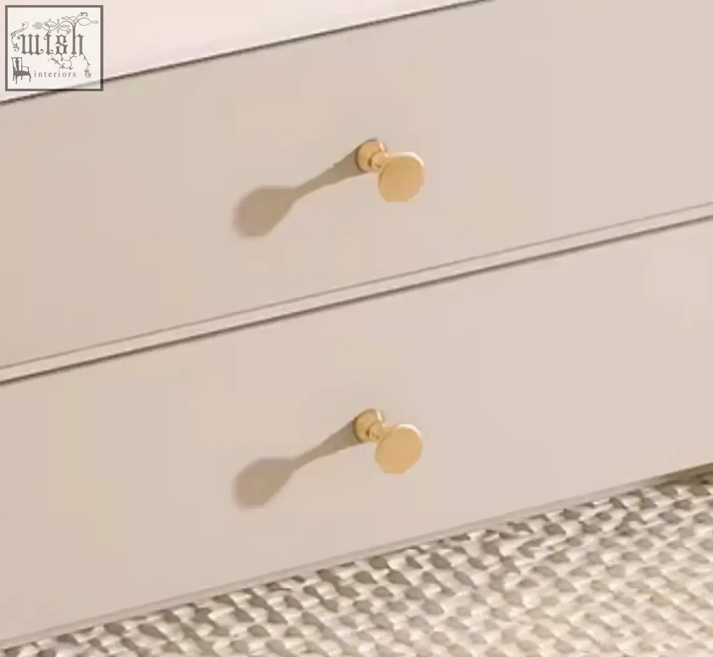 Gold-toned circular drawer pulls on a light beige dresser complement the cream eclipse nesting coffee table set