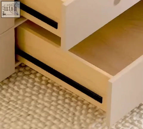White drawer with light wood interior and black sliding track of eclipse nesting coffee table set in cream color