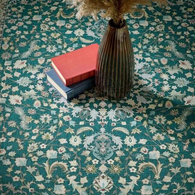A tall ribbed brown ceramic vase with dried pampas grass on an eco-washable green rug with medallion design