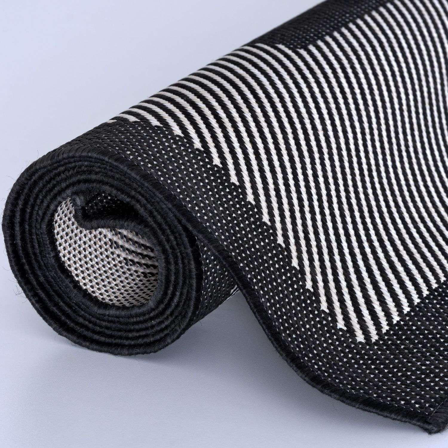 Black and white striped ecology outdoor rug showing textured mesh underside in outdoor rug black design