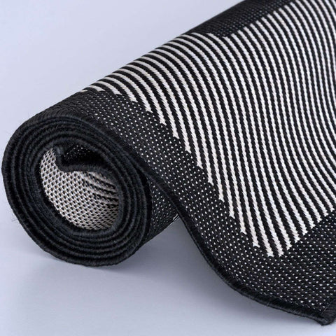 Black and white striped ecology outdoor rug showing textured mesh underside in outdoor rug black design