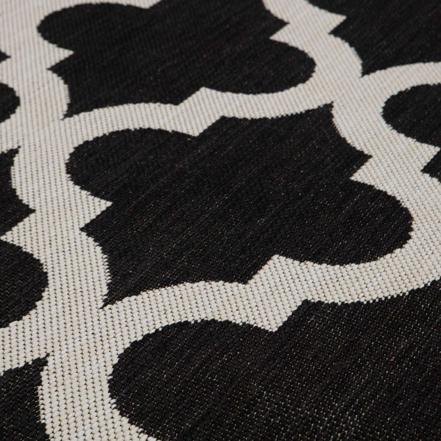 Black and white woven ecology outdoor rug with repeating quatrefoil pattern perfect for outdoor rug black use