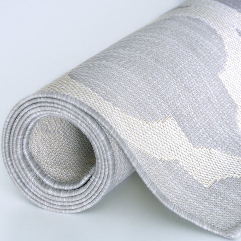 Rolled-up gray and white geometric-patterned ecology outdoor rug with woven texture perfect for outdoor use