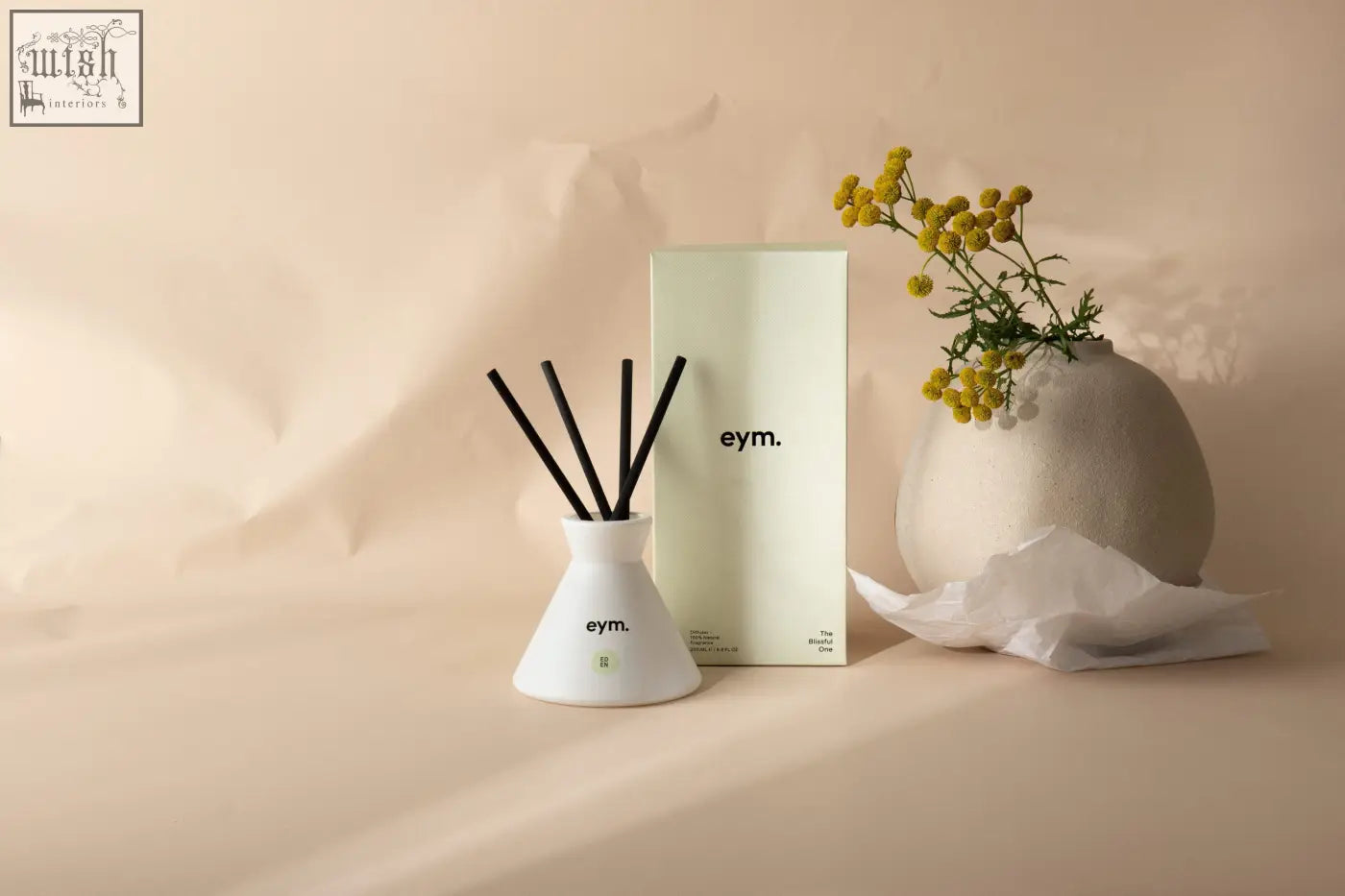 White ceramic eden diffuser with black reed sticks and eym branding on the base for home fragrance
