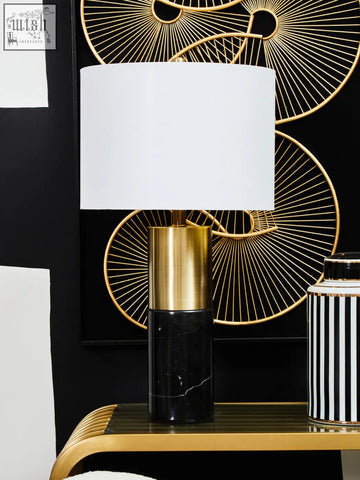 A sleek edgar black marble and gold table lamp with a white cylindrical shade and polished metal base