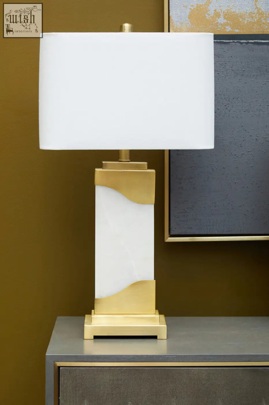 A modern edith table lamp with white marble base and gold accents topped with a white rectangular shade
