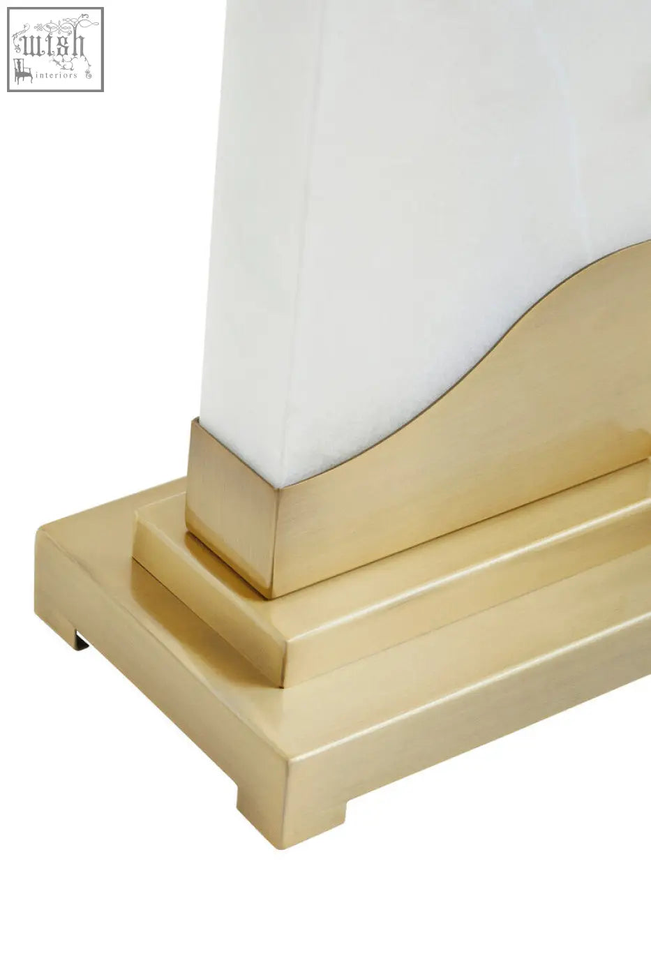 Gold-toned brass base with a stepped design holds a white glass shade in the edith table lamp with white marble base