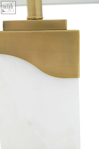 Gold-toned metal base with smooth curved edge on white marble edith table lamp lampshade