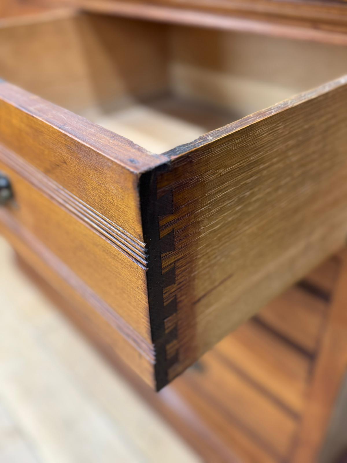 A polished edwardian walnut chest drawer with dovetail joints and subtle grooves for antique bedroom storage