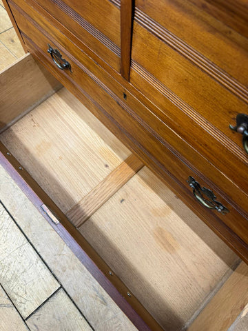 A warm medium-brown edwardian walnut chest of drawers with decorative grooves perfect for antique bedroom storage