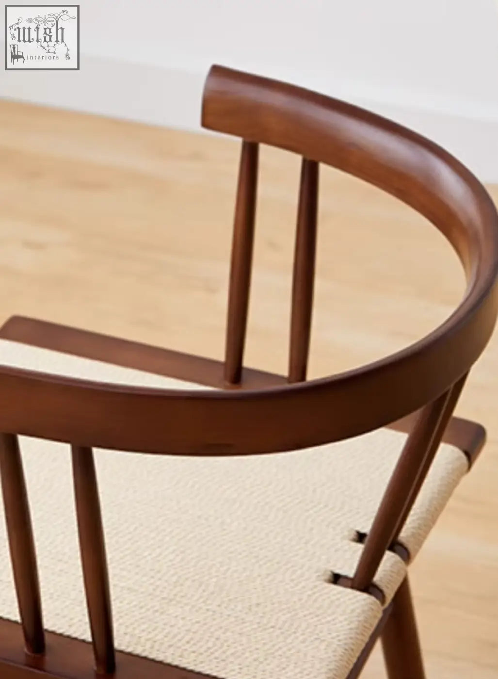 Eenoch dining chair with dark brown wooden frame, curved backrest, vertical spindles, and beige woven rattan seat