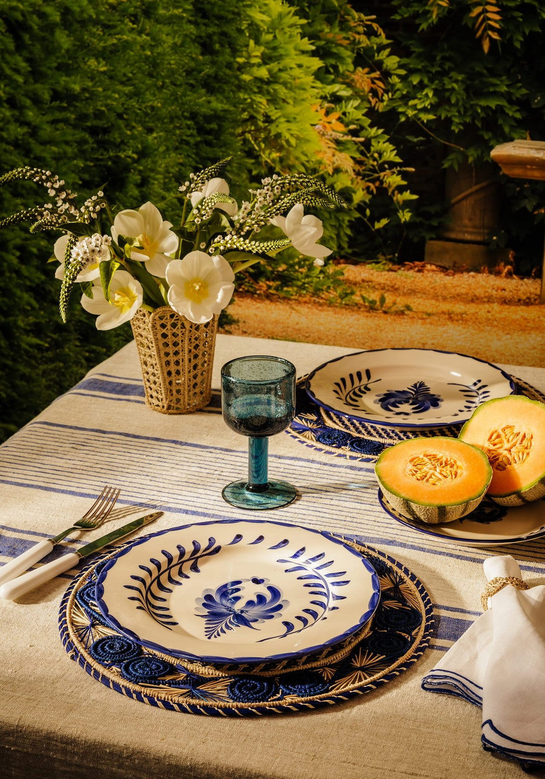 Blue and white ceramic plates with hand-painted floral designs matching the eleanor wine glass blue set